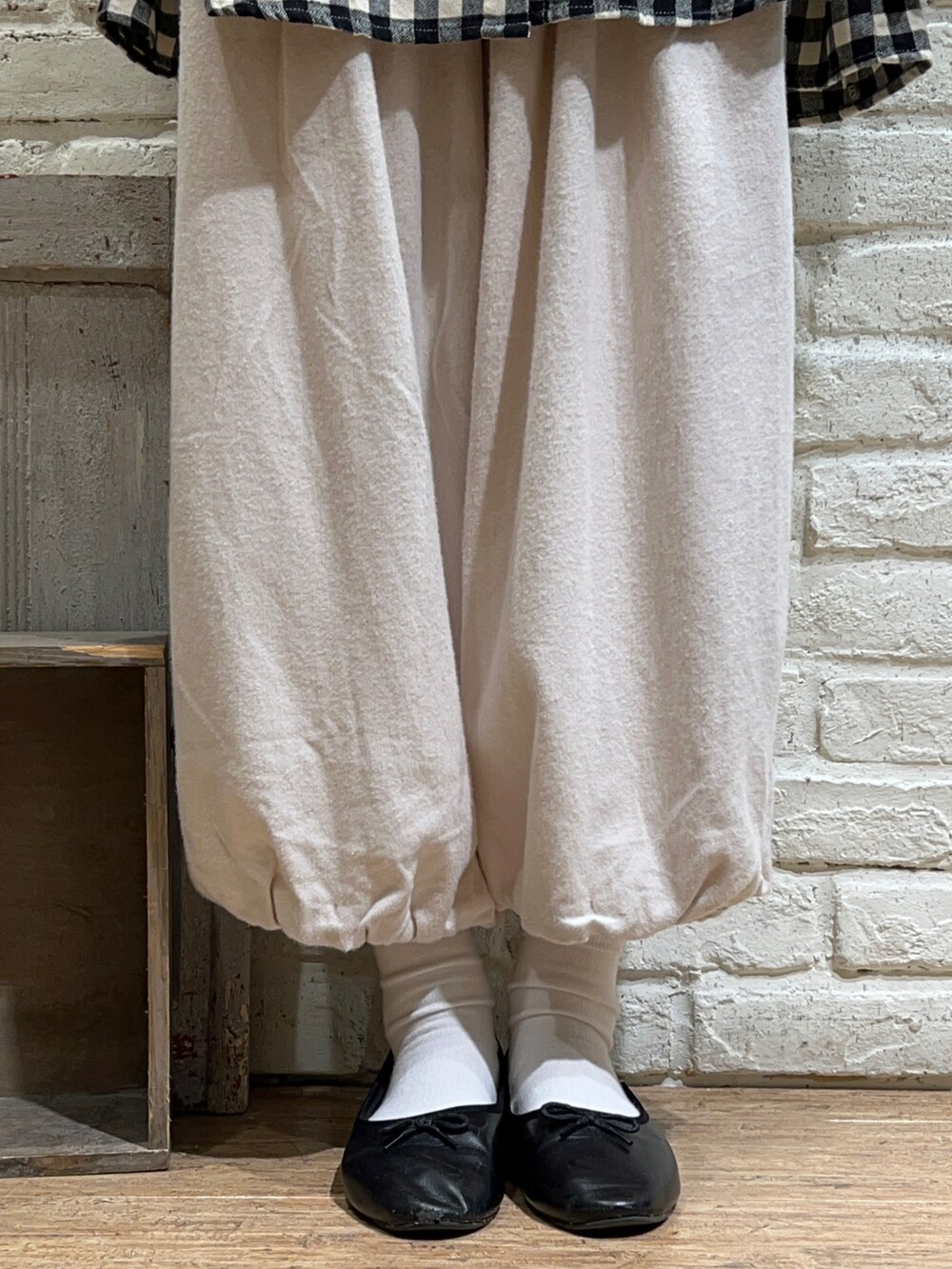グリーン系のカーディガン/ボレロ、ブラック系のチュニック、ホワイト系のその他パンツを着用したレディースの冬コーディネートの5枚目の写真