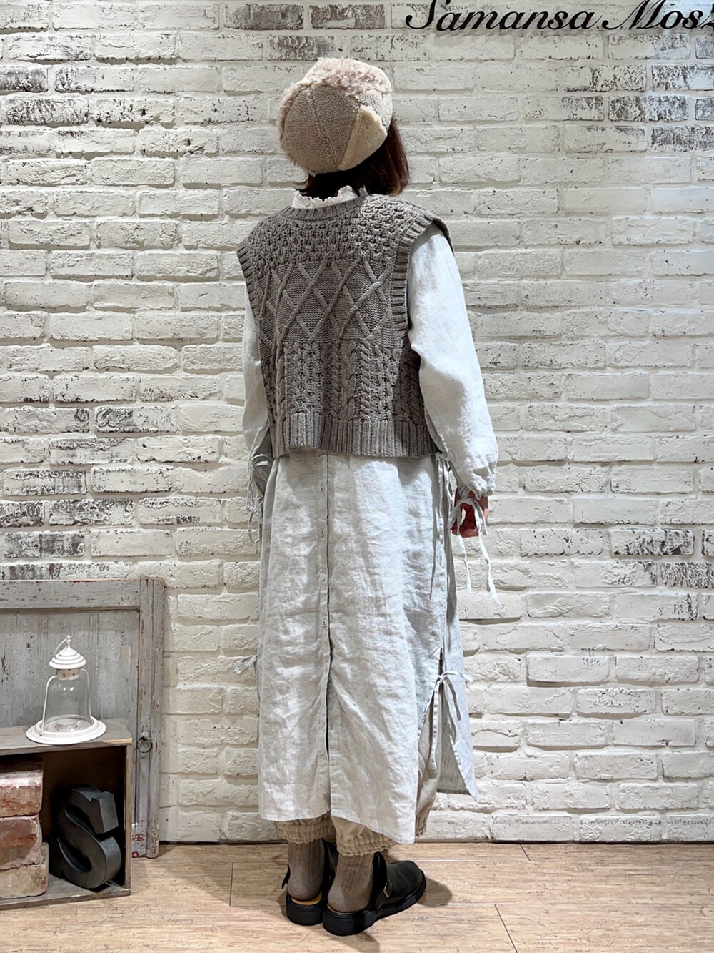 ホワイト系のTシャツ/カットソー、ブラウン系のベスト、グリーン系のワンピースを着用したレディースの冬コーディネートの3枚目の写真