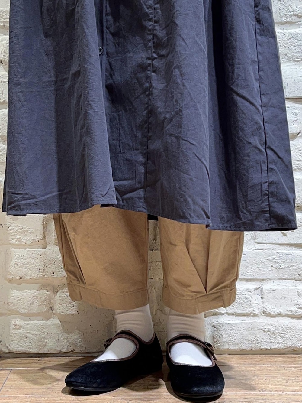 ブラック系のベスト、グレー系のワンピース、ベージュ系のその他パンツを着用したレディースの秋コーディネートの5枚目の写真