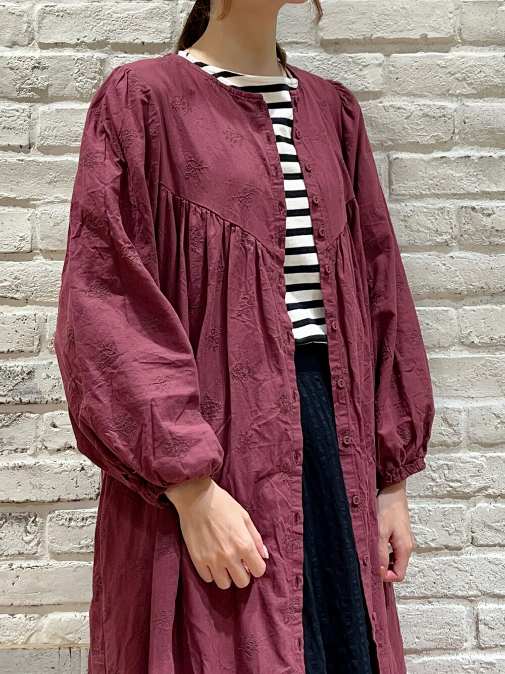 ホワイト系のTシャツ/カットソー、レッド系のワンピース、ブラック系のスカートを着用したレディースの秋コーディネートの2枚目の写真