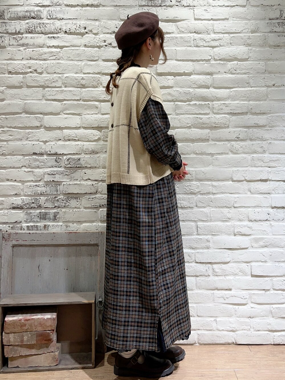 ホワイト系のベスト、ブラック系のTシャツ/カットソー、ブラウン系のワンピースを着用したレディースの秋コーディネートの3枚目の写真