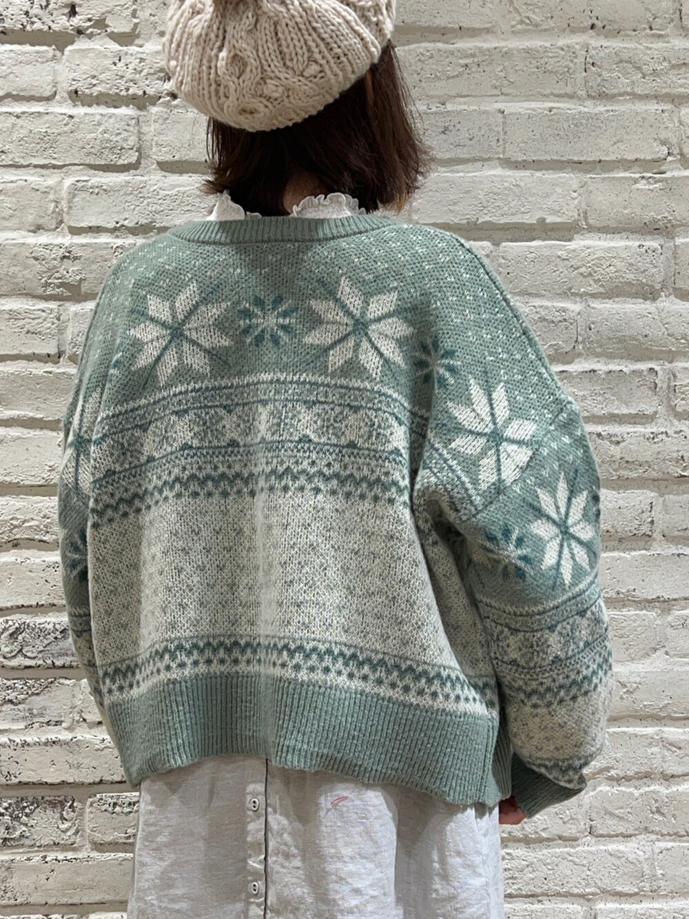 ホワイト系のTシャツ/カットソー、グリーン系のカーディガン/ボレロ、グリーン系のワンピースを着用したレディースの冬コーディネートの5枚目の写真