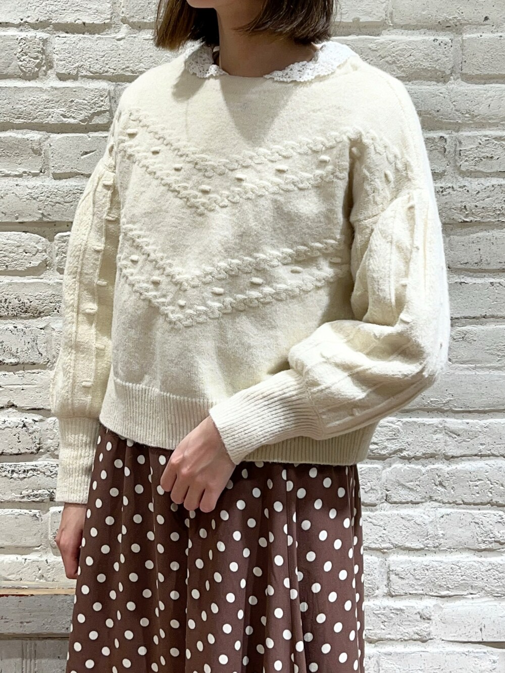 ホワイト系のシャツ/ブラウス、ホワイト系のニット/セーター、ブラウン系のスカートを着用したレディースの冬コーディネートの2枚目の写真