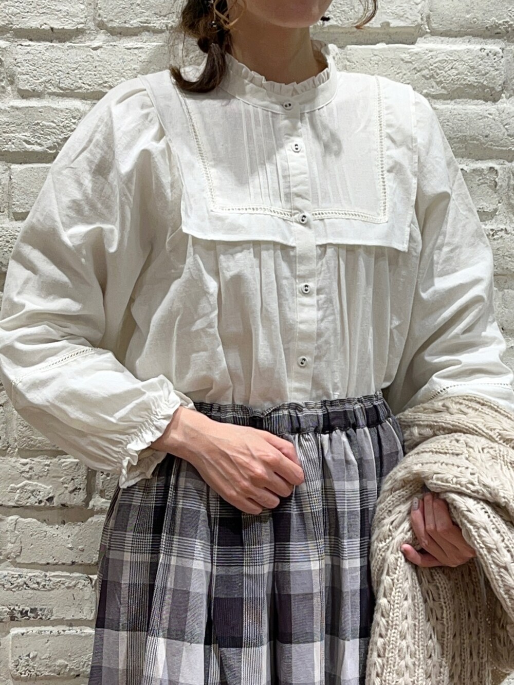 ホワイト系のTシャツ/カットソー、ホワイト系のシャツ/ブラウス、ベージュ系のニット/セーターを着用したレディースの冬コーディネートの5枚目の写真