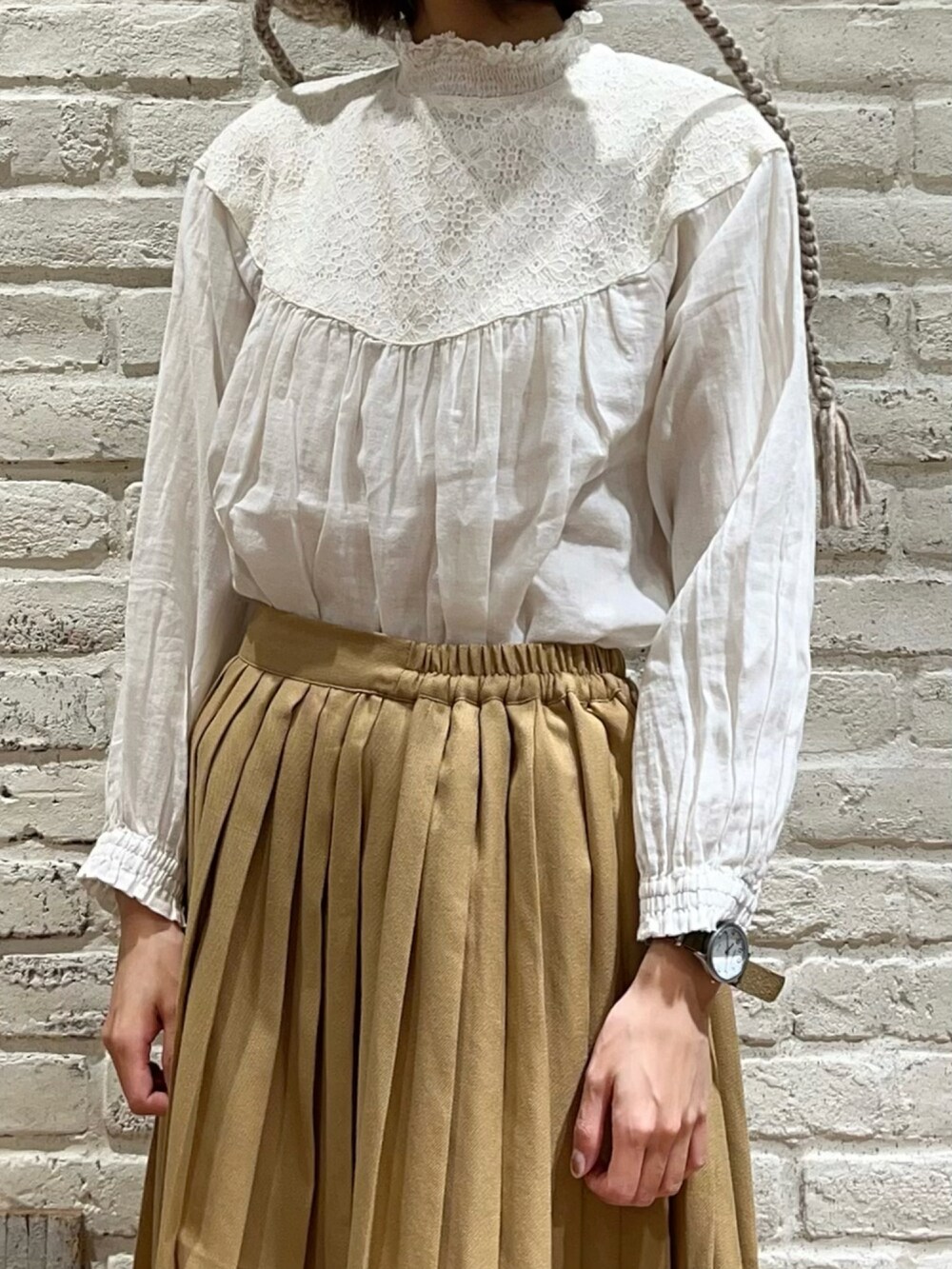 ホワイト系のシャツ/ブラウス、ホワイト系のニット/セーター、ベージュ系のスカートを着用したレディースの冬コーディネートの3枚目の写真