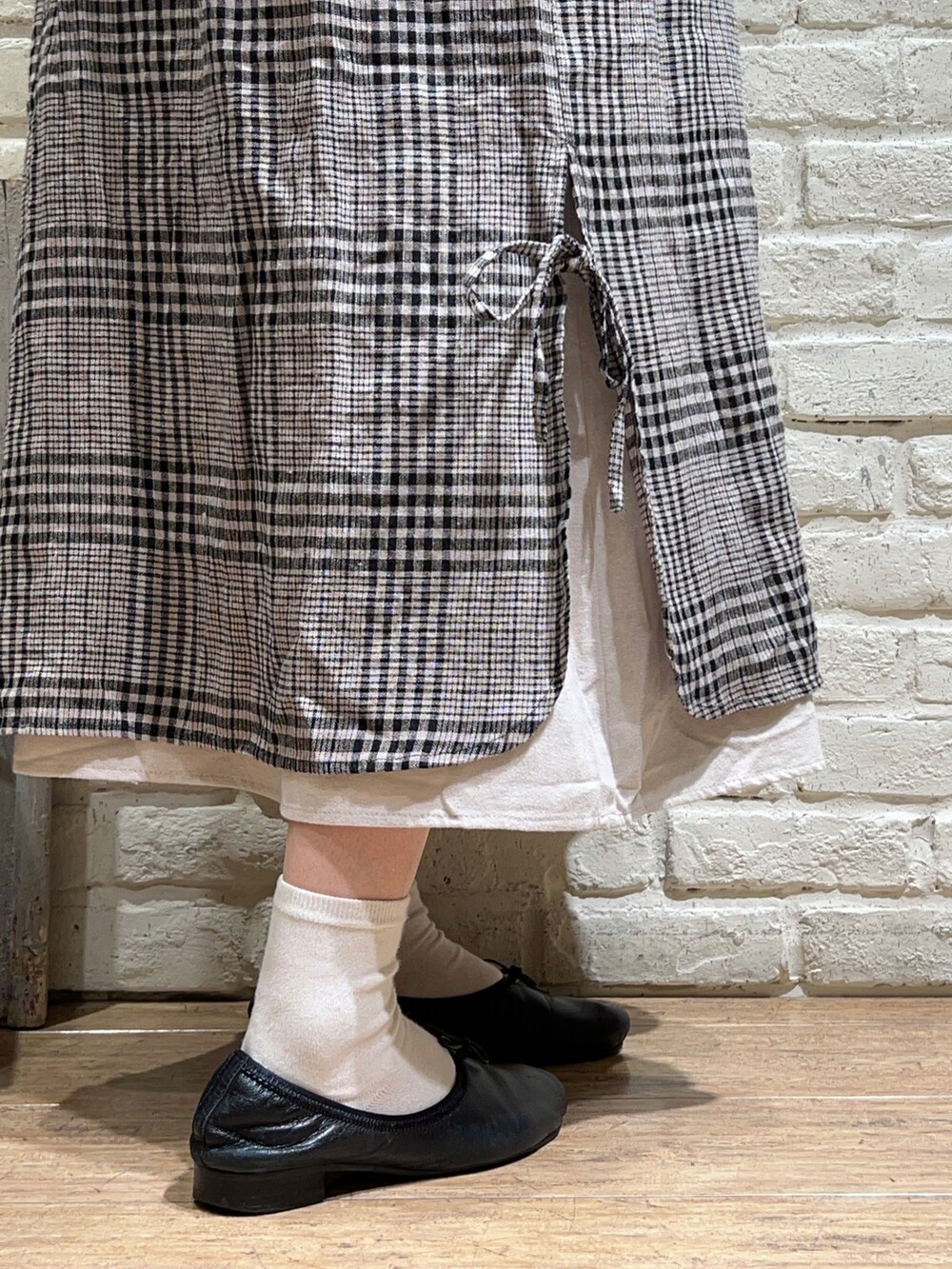 ブラック系のニット/セーター、ホワイト系のワンピース、ホワイト系のワンピースを着用したレディースの冬コーディネートの5枚目の写真