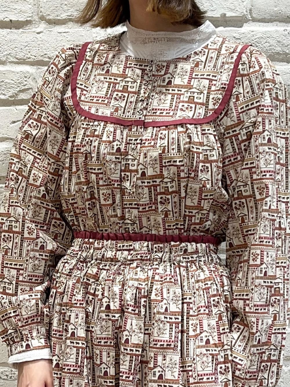 ホワイト系のシャツ/ブラウス、レッド系のシャツ/ブラウス、ベージュ系のノーカラーコートを着用したレディースの冬コーディネートの3枚目の写真