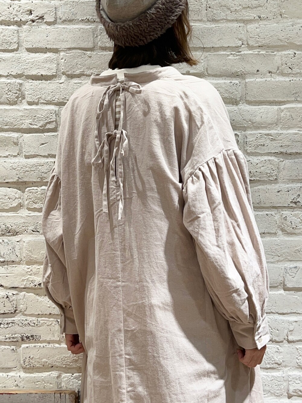 ホワイト系のTシャツ/カットソー、ホワイト系のニット/セーター、ベージュ系のワンピースを着用したレディースの冬コーディネートの5枚目の写真