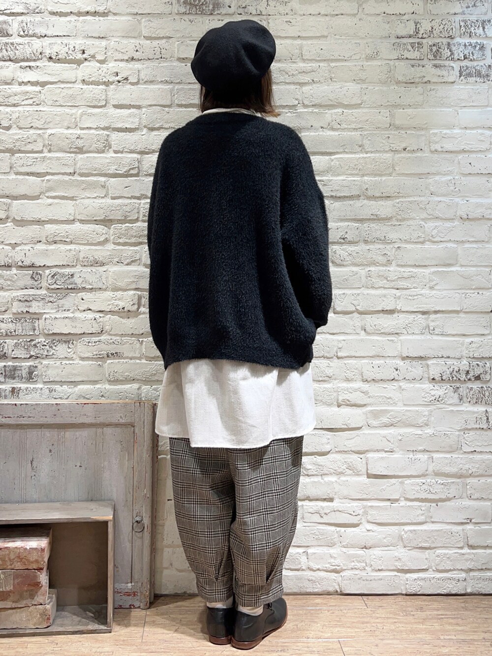 ホワイト系のニット/セーター、グレー系のチュニック、ブラック系のカーディガン/ボレロを着用したレディースの冬コーディネートの4枚目の写真