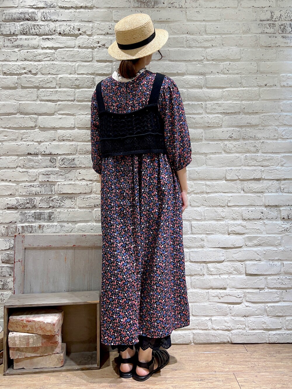 ブラック系のベスト、ピンク系のワンピース、ブラック系のハンドバッグを着用したレディースの夏コーディネートの3枚目の写真