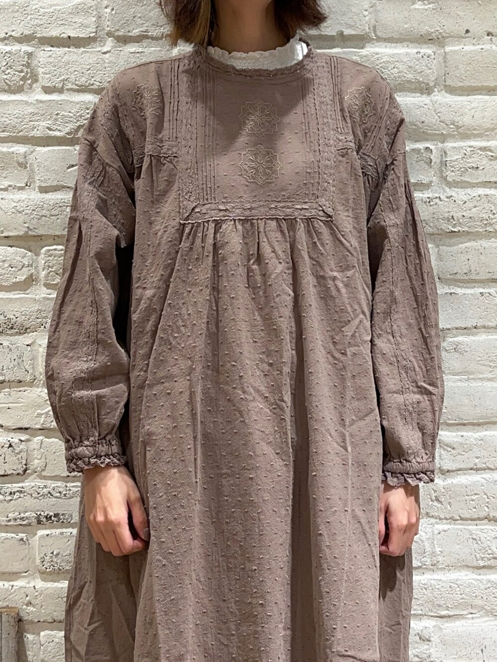 ホワイト系のTシャツ/カットソー、ホワイト系のベスト、ブラウン系のワンピースを着用したレディースの冬コーディネートの3枚目の写真