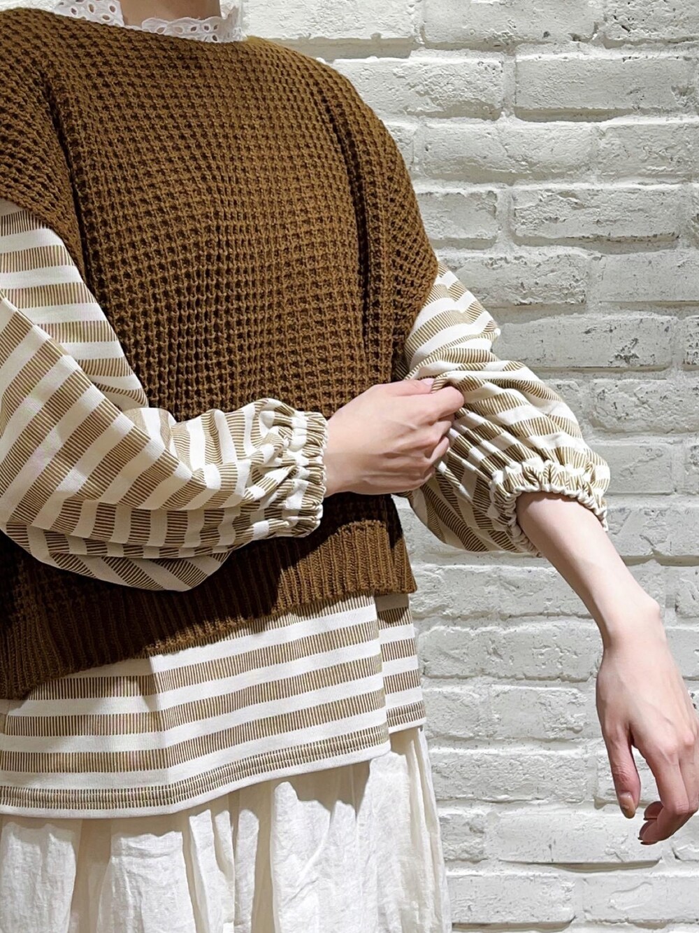 ホワイト系のTシャツ/カットソー、ブラウン系のベスト、イエロー系のTシャツ/カットソーを着用したレディースの秋コーディネートの2枚目の写真