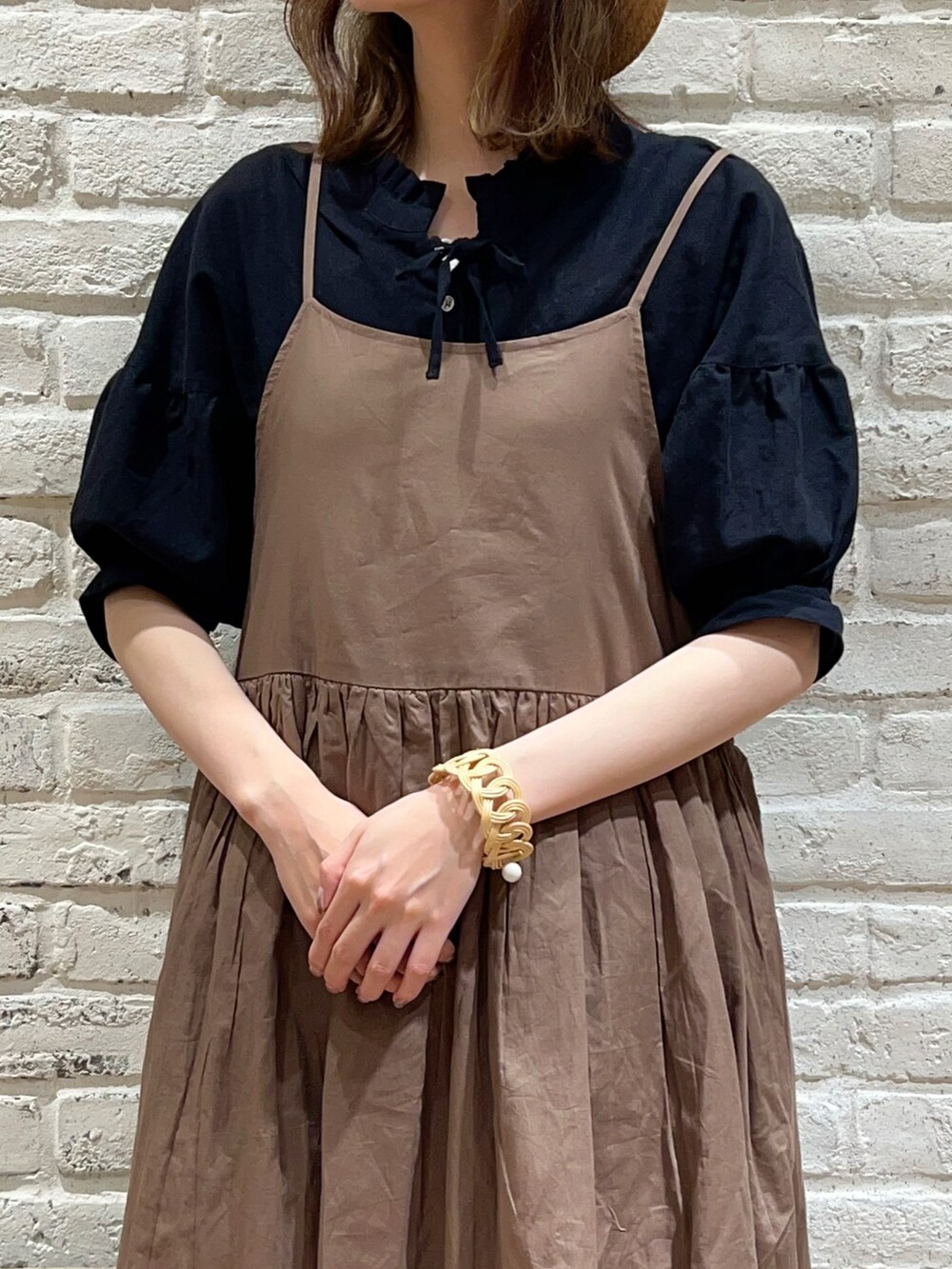 ホワイト系のタンクトップ、ブラック系のチュニック、ブラウン系のワンピースを着用したレディースの夏コーディネートの2枚目の写真