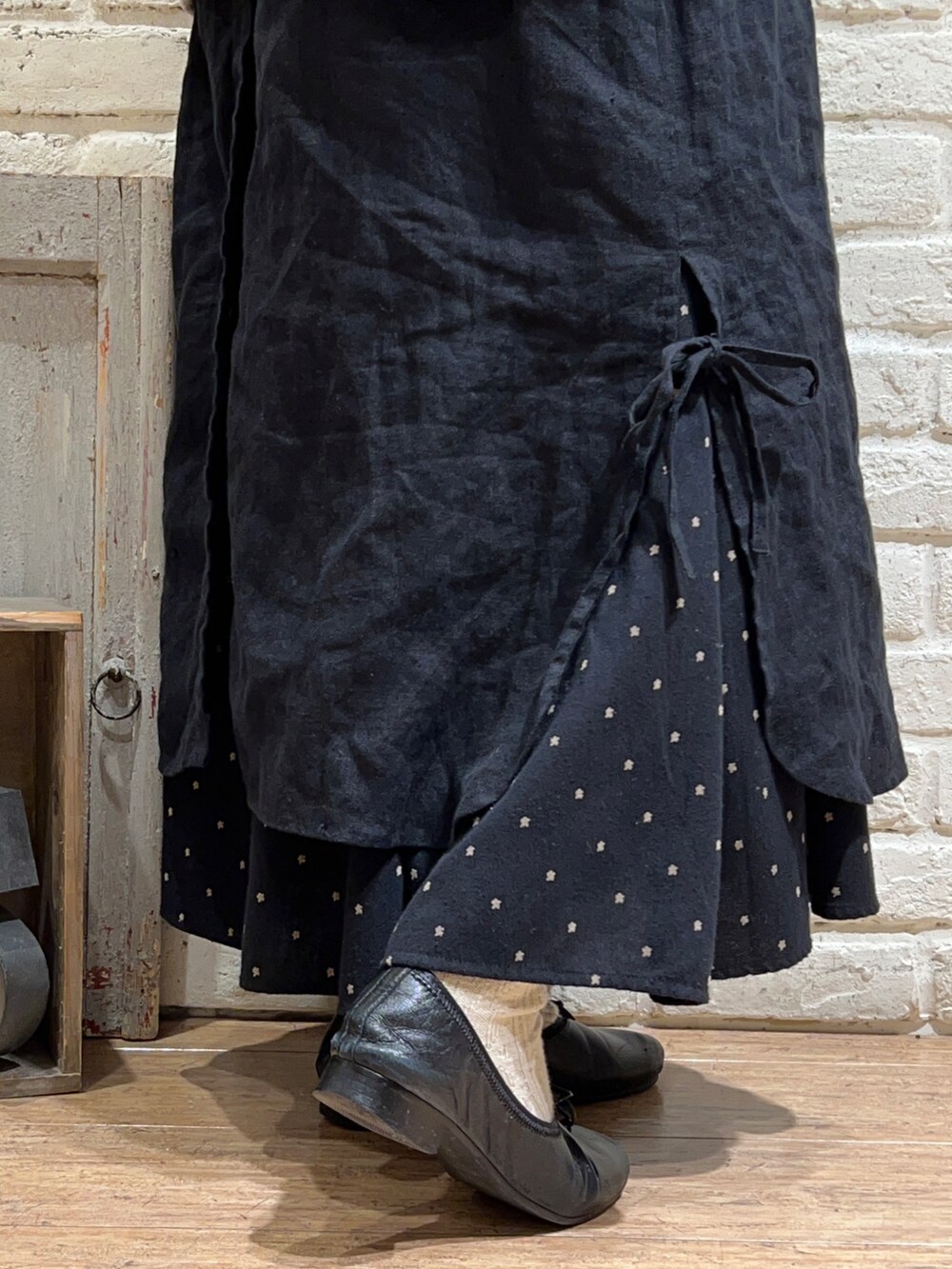 ホワイト系のTシャツ/カットソー、ブラウン系のカーディガン/ボレロ、ブラック系のワンピースを着用したレディースの冬コーディネートの5枚目の写真