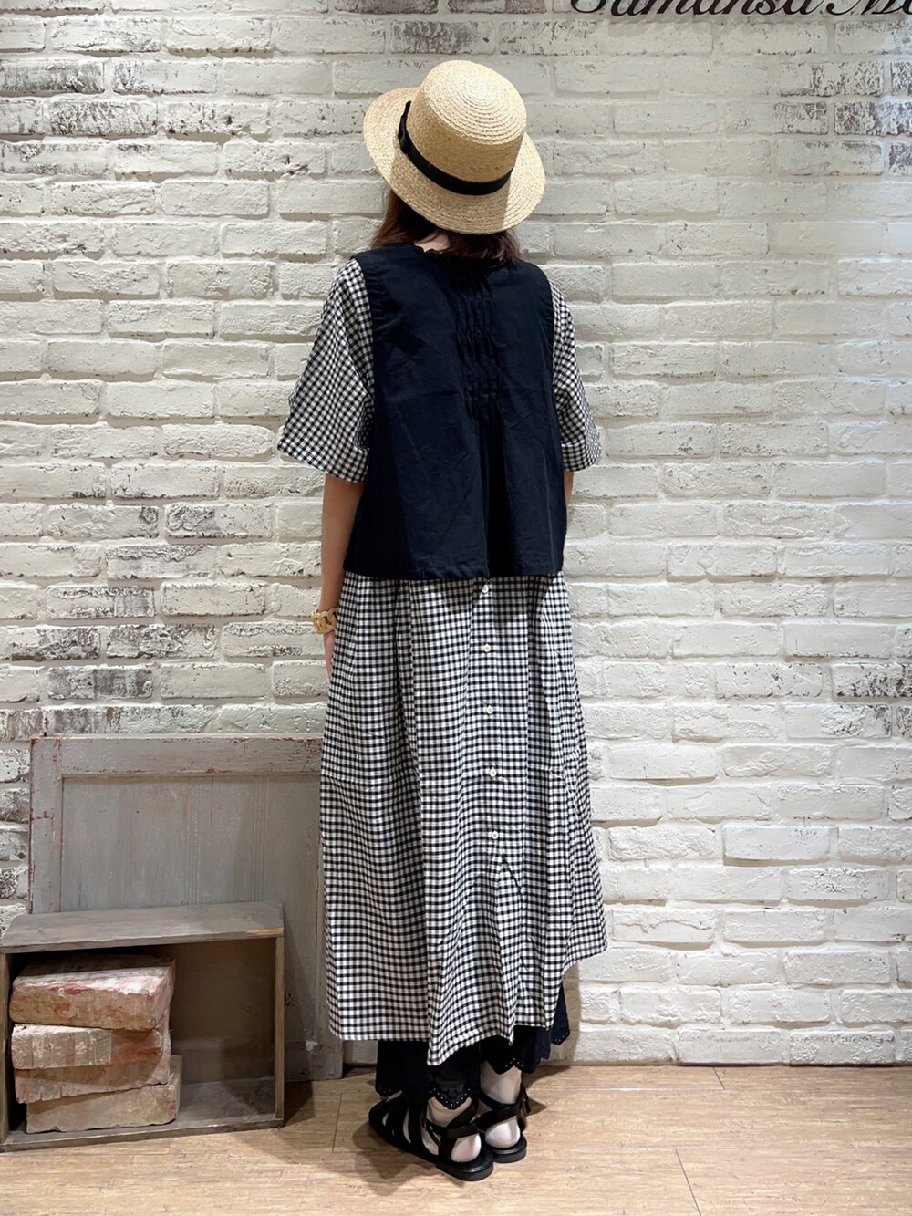 ブラック系のベスト、ブラック系のハンドバッグ、ホワイト系のワンピースを着用したレディースの秋コーディネートの3枚目の写真