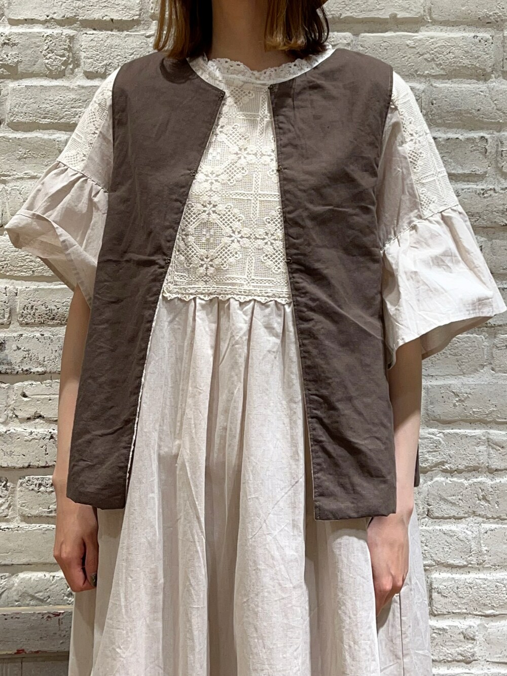 ホワイト系のタンクトップ、ホワイト系のベスト、ホワイト系のワンピースを着用したレディースの春コーディネートの2枚目の写真