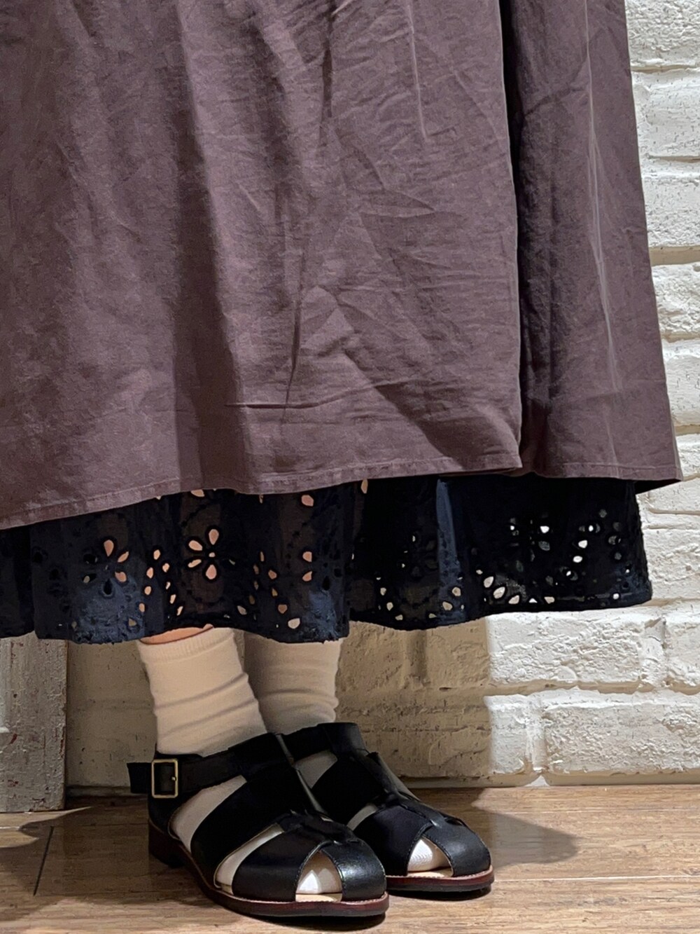 グレー系のワンピース、ブラック系のハンドバッグ、ブラック系のスカートを着用したレディースの春コーディネートの5枚目の写真