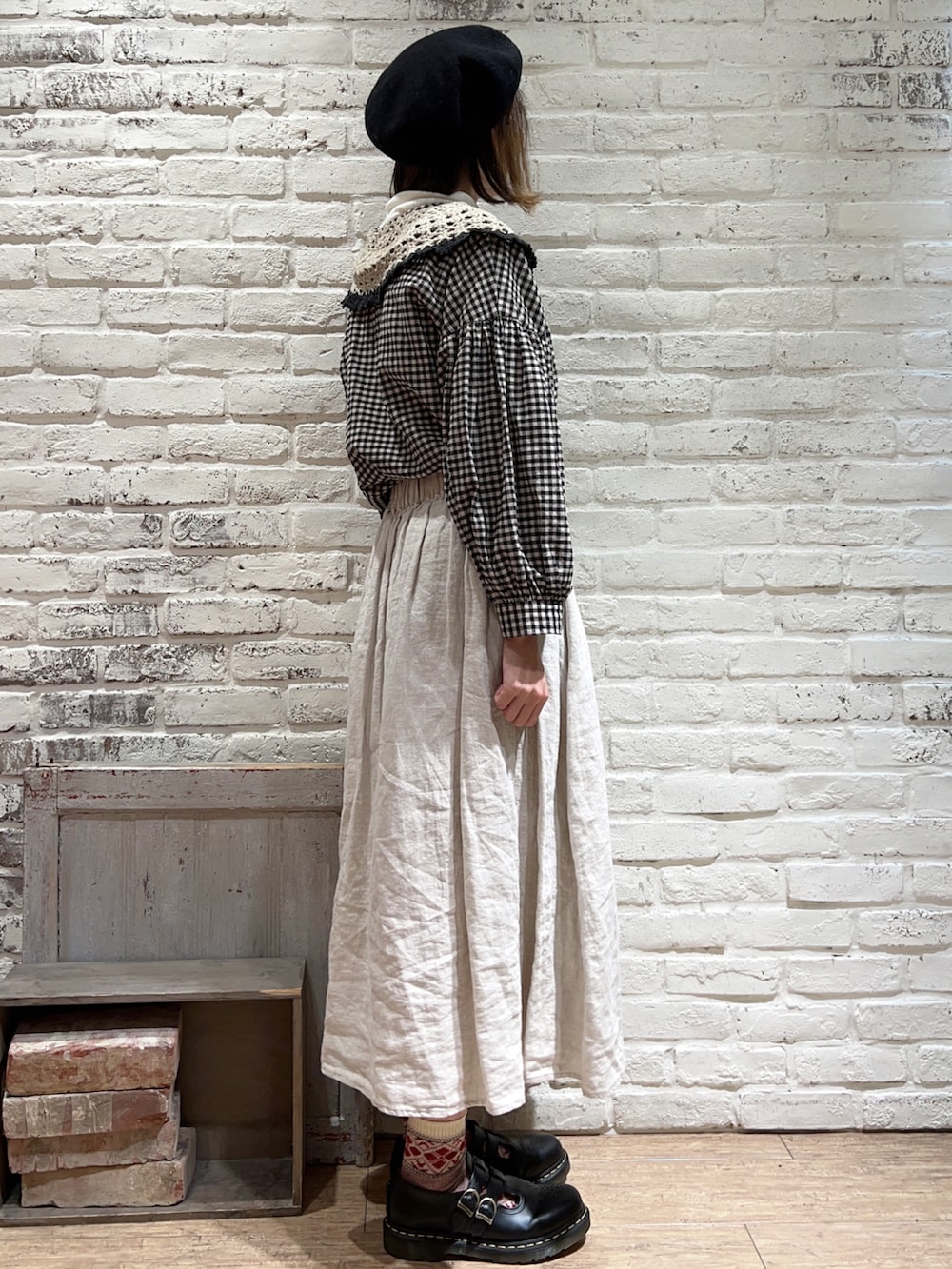 ホワイト系のニット/セーター、ブラック系のチュニック、ホワイト系のスカートを着用したレディースの冬コーディネートの3枚目の写真