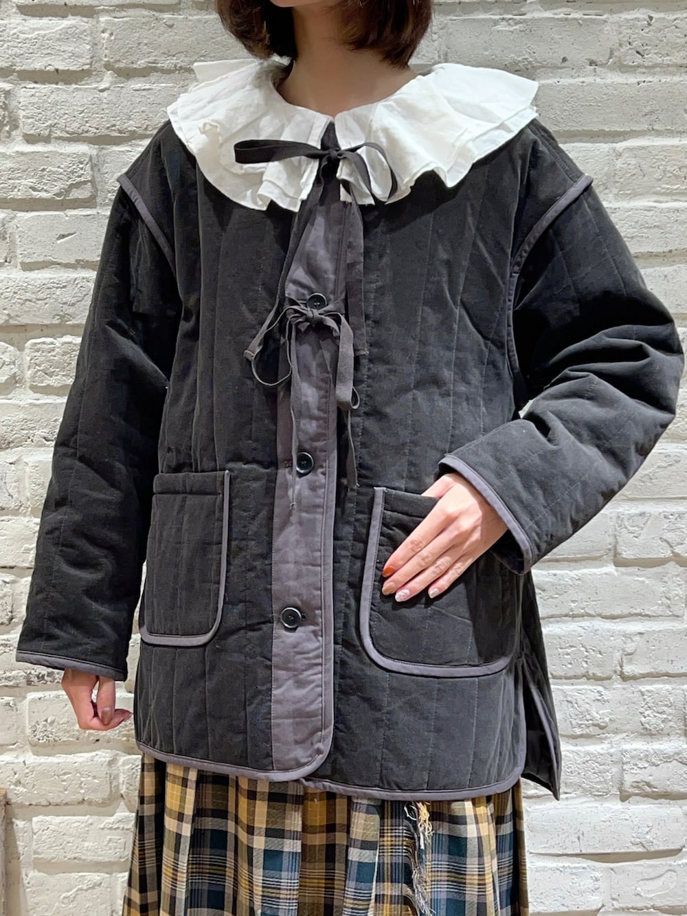 ホワイト系のシャツ/ブラウス、グレー系のノーカラージャケット、グリーン系のスカートを着用したレディースの冬コーディネートの2枚目の写真