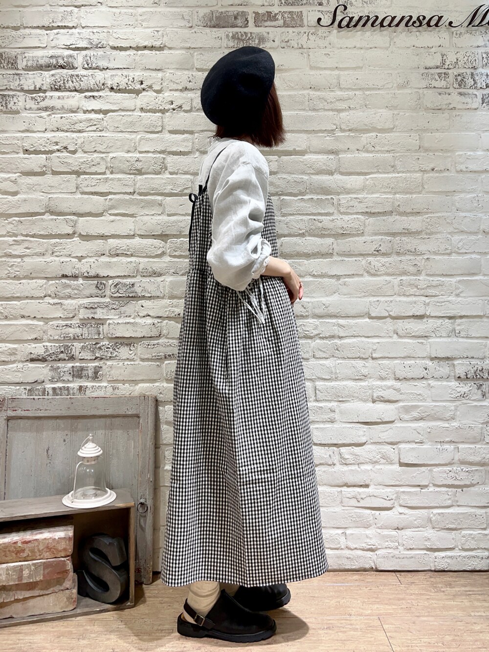 ブラック系のサンダル、グリーン系のチュニック、ホワイト系のTシャツ/カットソーを着用したレディースの冬コーディネートの2枚目の写真