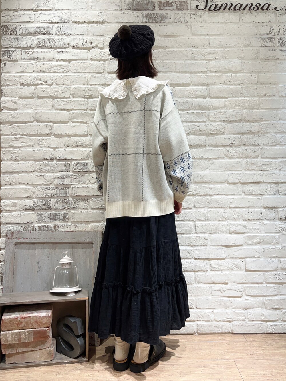 ホワイト系のシャツ/ブラウス、ホワイト系のニット/セーター、ブラック系のスカートを着用したレディースの冬コーディネートの3枚目の写真