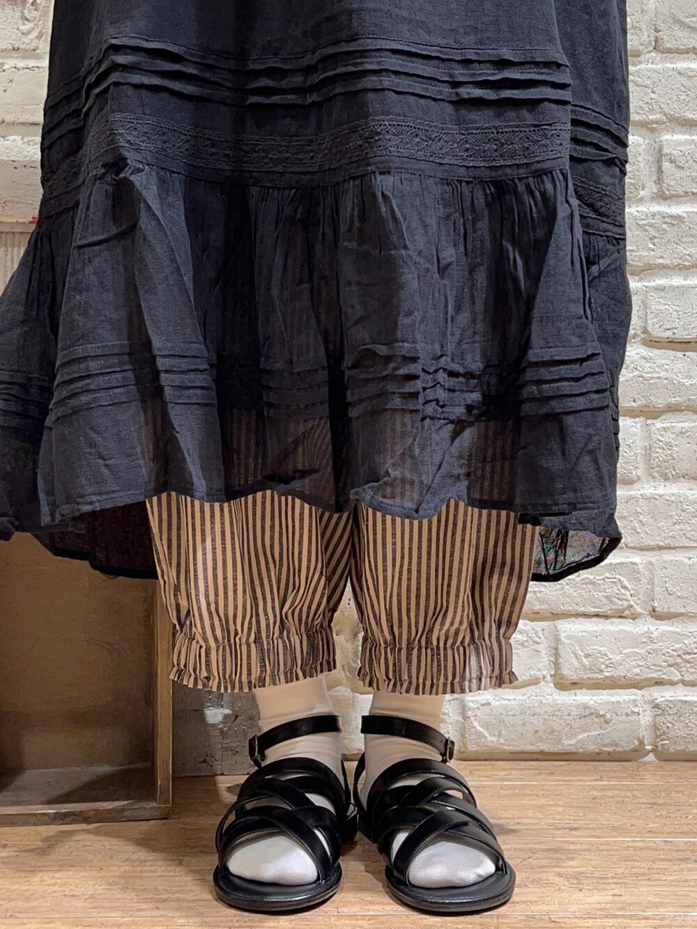 ベージュ系のTシャツ/カットソー、ベージュ系のカーディガン/ボレロ、ブラック系のワンピースを着用したレディースの秋コーディネートの5枚目の写真