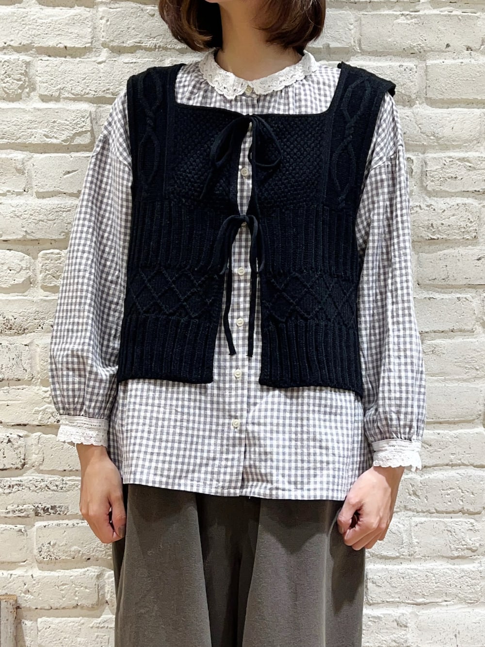 グレー系のシャツ/ブラウス、ブラック系のベスト、ホワイト系のノーカラージャケットを着用したレディースの冬コーディネートの3枚目の写真