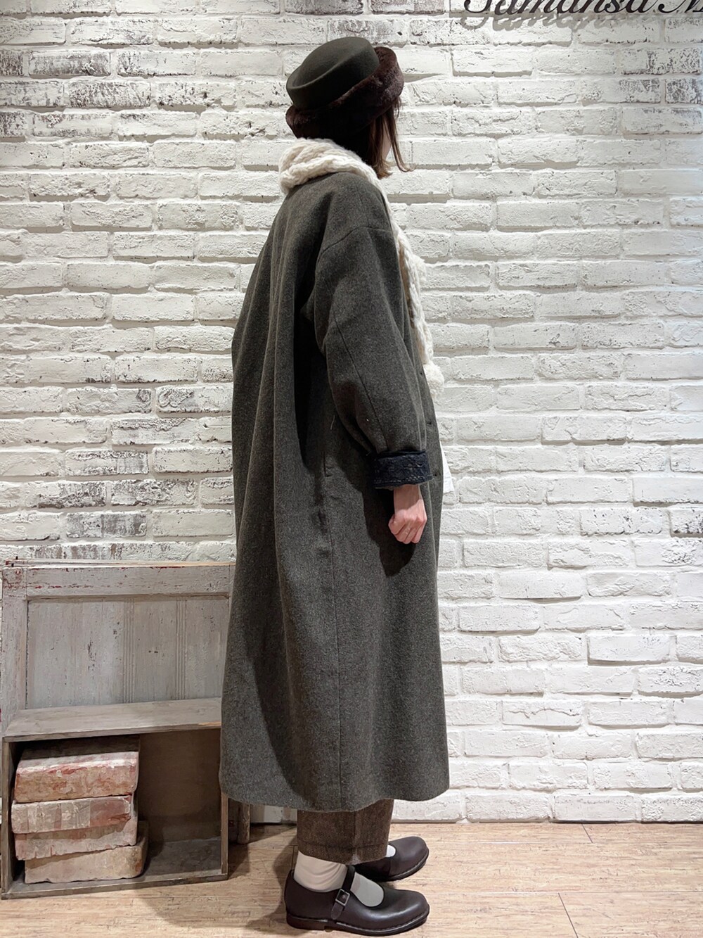 グリーン系のノーカラーコート、ホワイト系のシャツ/ブラウス、ブラウン系のその他パンツを着用したレディースの冬コーディネートの4枚目の写真