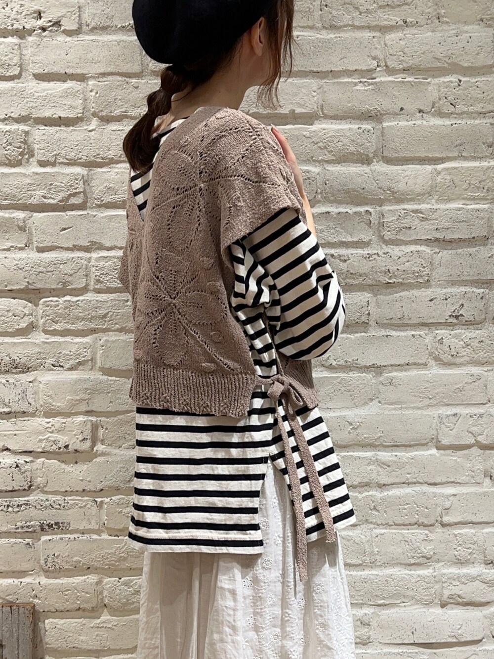 ホワイト系のTシャツ/カットソー、ベージュ系のベスト、ブラック系のハットを着用したレディースの秋コーディネートの4枚目の写真