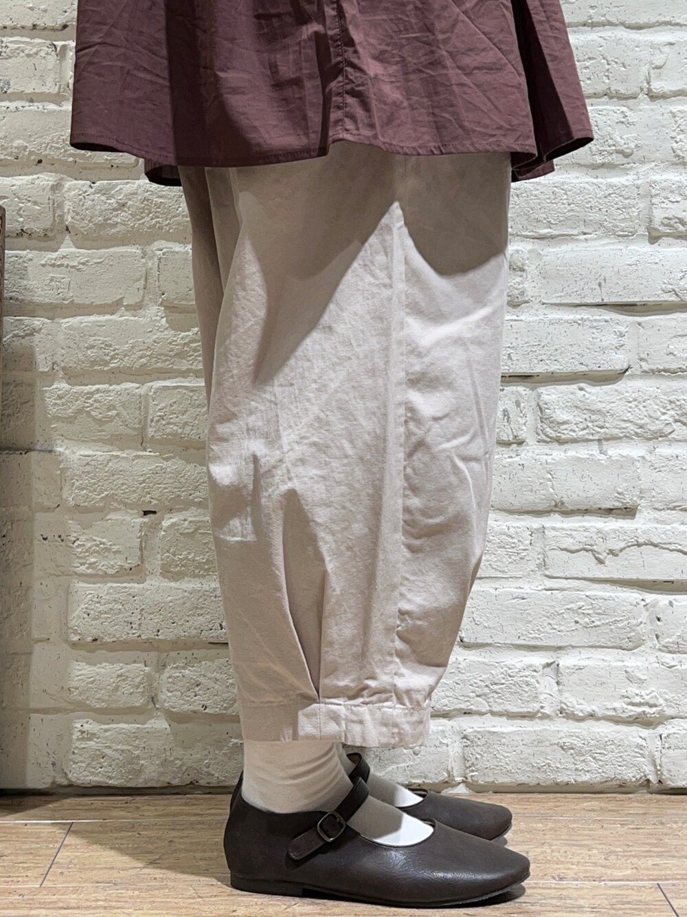 ホワイト系のTシャツ/カットソー、ブラウン系のチュニック、ベージュ系のハンドバッグを着用したレディースの夏コーディネートの5枚目の写真