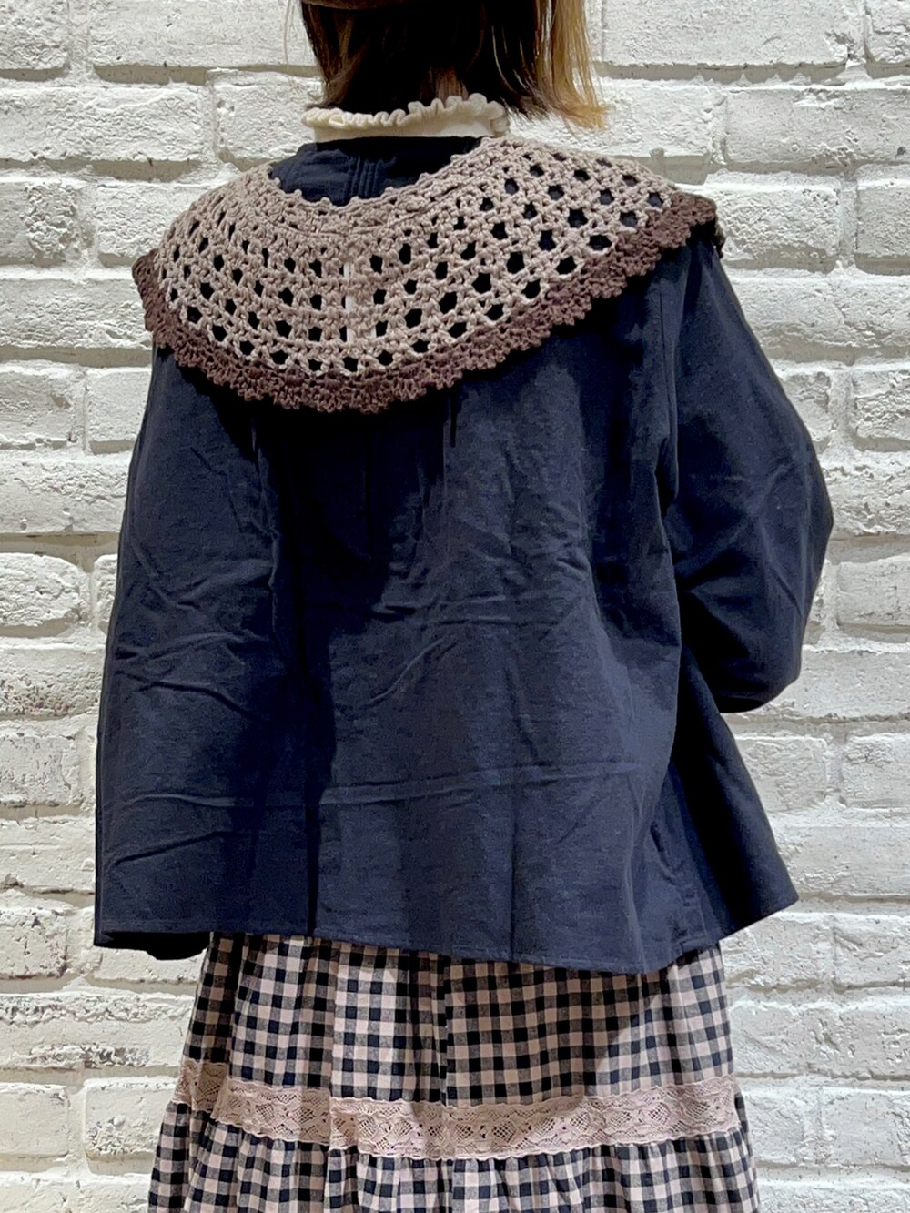 ホワイト系のニット/セーター、ブラック系のシャツ/ブラウス、ブラウン系のハンドバッグを着用したレディースの秋コーディネートの5枚目の写真