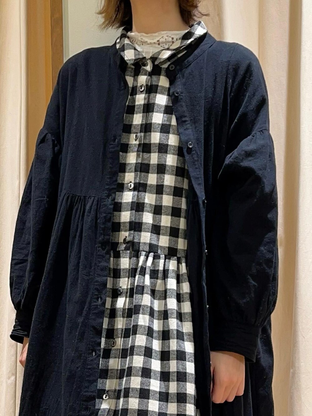 ホワイト系のTシャツ/カットソー、ブラック系のシャツワンピース、ブラック系のワンピースを着用したレディースの冬コーディネートの2枚目の写真