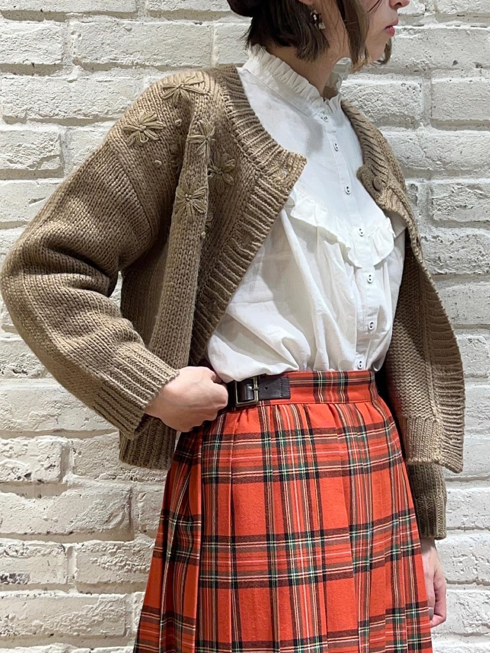 ホワイト系のシャツ/ブラウス、ブラウン系のカーディガン/ボレロ、レッド系のスカートを着用したレディースの冬コーディネートの3枚目の写真