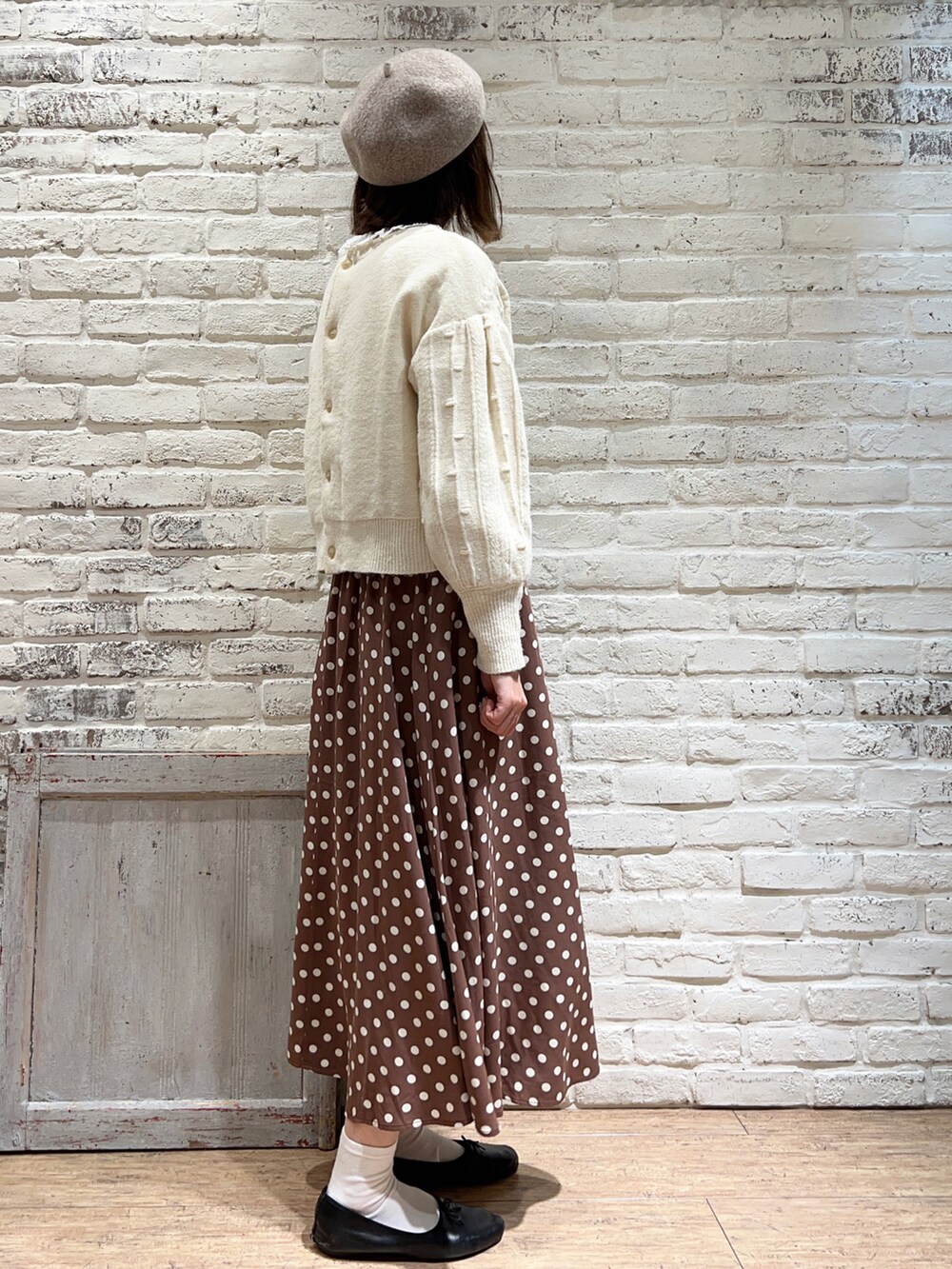 ホワイト系のシャツ/ブラウス、ホワイト系のニット/セーター、ブラウン系のスカートを着用したレディースの冬コーディネートの3枚目の写真