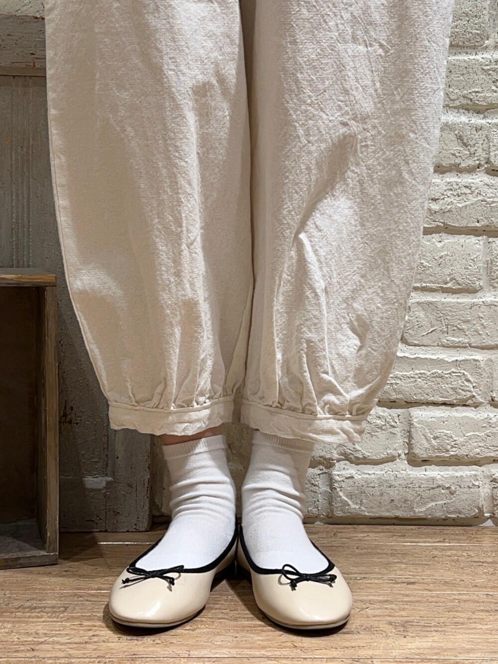 ベージュ系のシャツ/ブラウス、ベージュ系のベスト、ホワイト系のハンドバッグを着用したレディースの春コーディネートの5枚目の写真