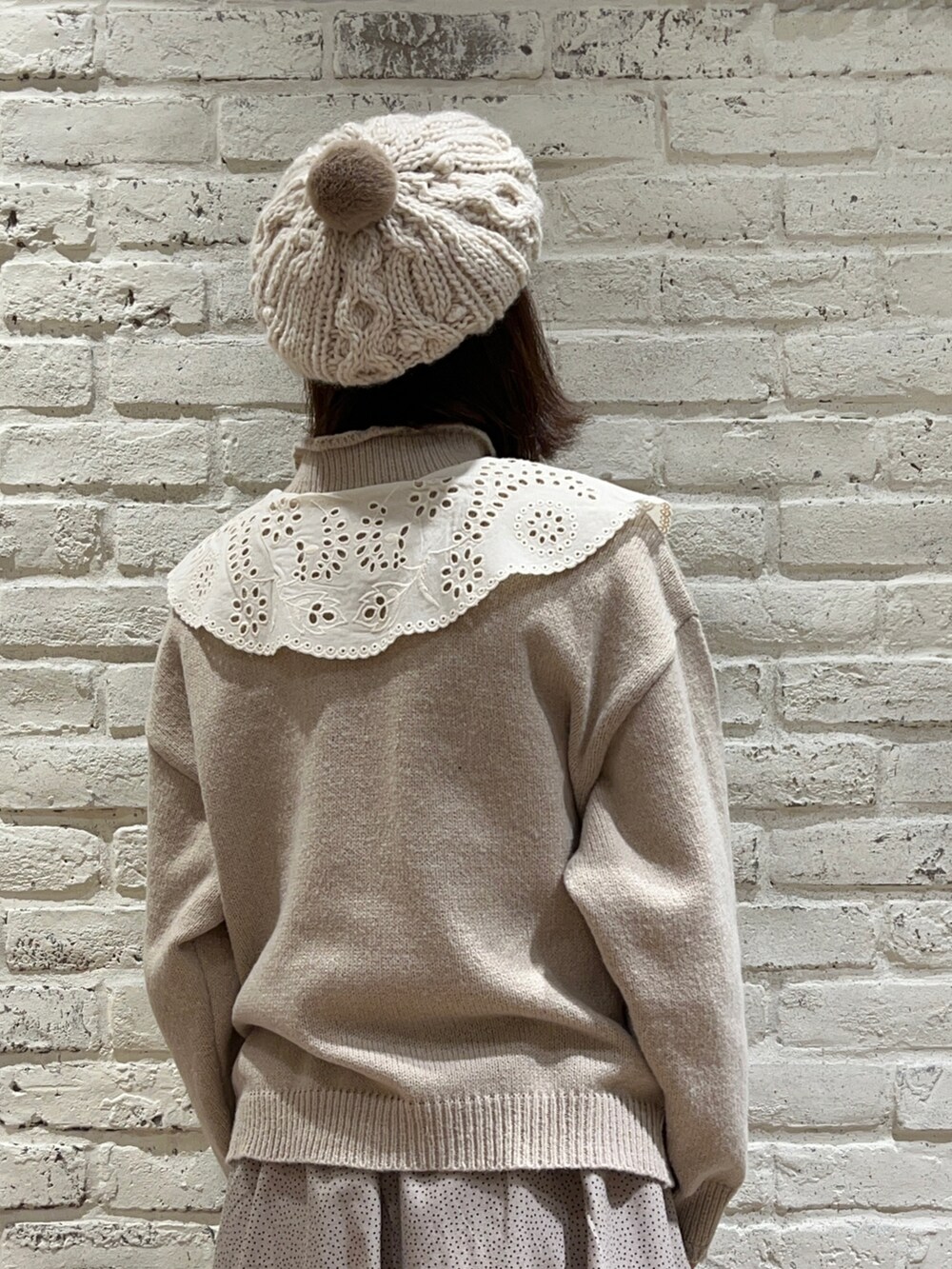 ホワイト系のシャツ/ブラウス、ベージュ系のニット/セーター、ベージュ系のスカートを着用したレディースの冬コーディネートの2枚目の写真