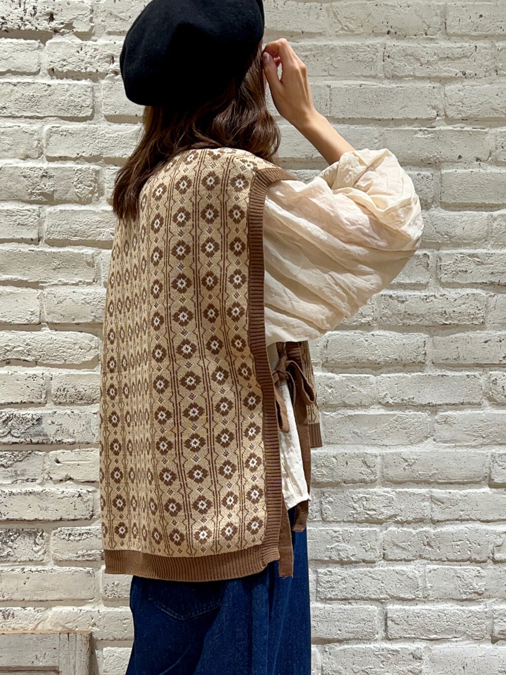 ブラウン系のベスト、ホワイト系のシャツ/ブラウス、ブルー系のデニムパンツを着用したレディースの秋コーディネートの4枚目の写真