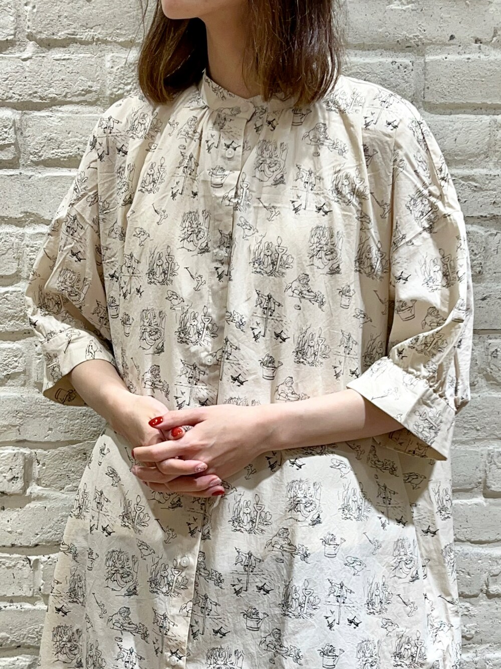 ブラック系のベスト、ブラック系のハンドバッグ、ホワイト系のワンピースを着用したレディースの夏コーディネートの3枚目の写真