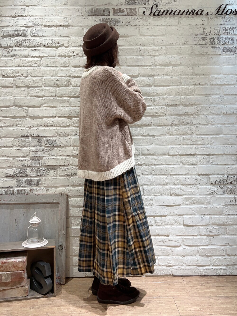 ホワイト系のニット/セーター、ベージュ系のカーディガン/ボレロ、グリーン系のスカートを着用したレディースの冬コーディネートの3枚目の写真