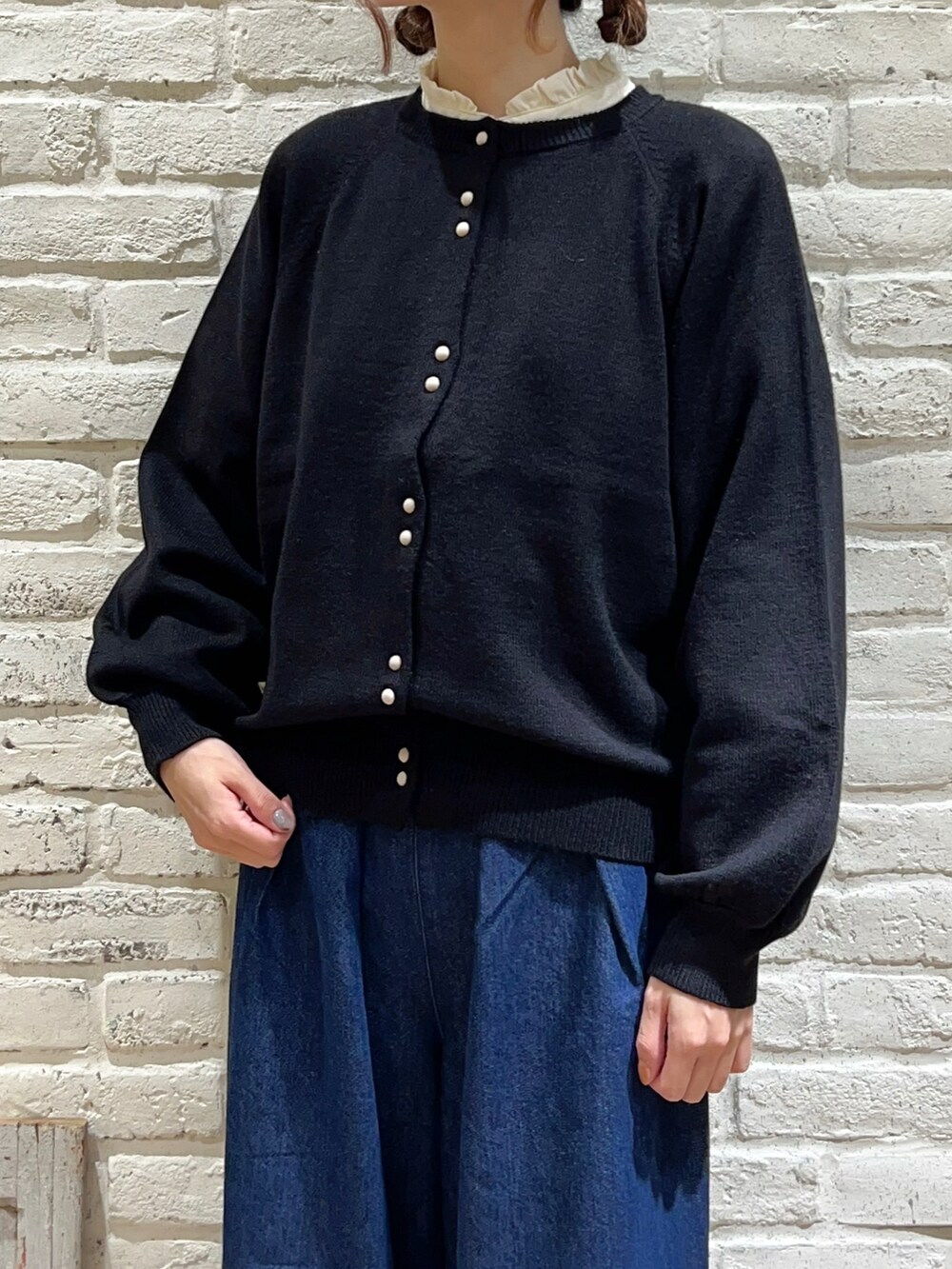 ホワイト系のシャツ/ブラウス、ブラック系のカーディガン/ボレロ、ブルー系のデニムパンツを着用したレディースの秋コーディネートの2枚目の写真