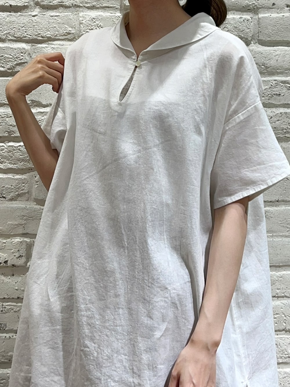 ベージュ系のTシャツ/カットソー、イエロー系のカーディガン/ボレロ、ホワイト系のシャツ/ブラウスを着用したレディースの夏コーディネートの2枚目の写真