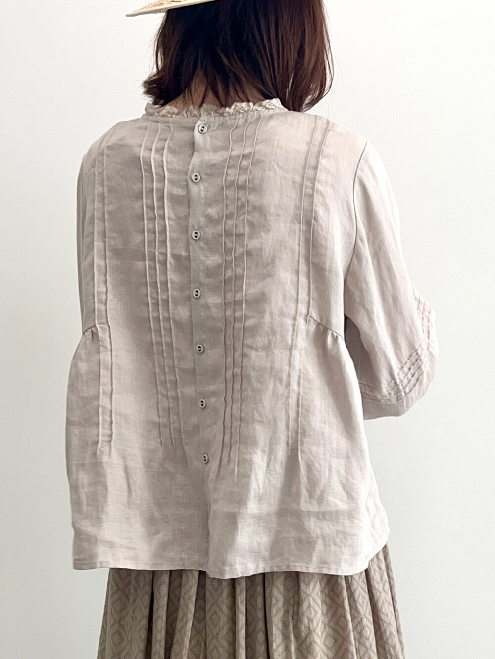 グレー系のスカート、ホワイト系のパンプス、ベージュ系のシャツ/ブラウスを着用したレディースの春コーディネートの4枚目の写真