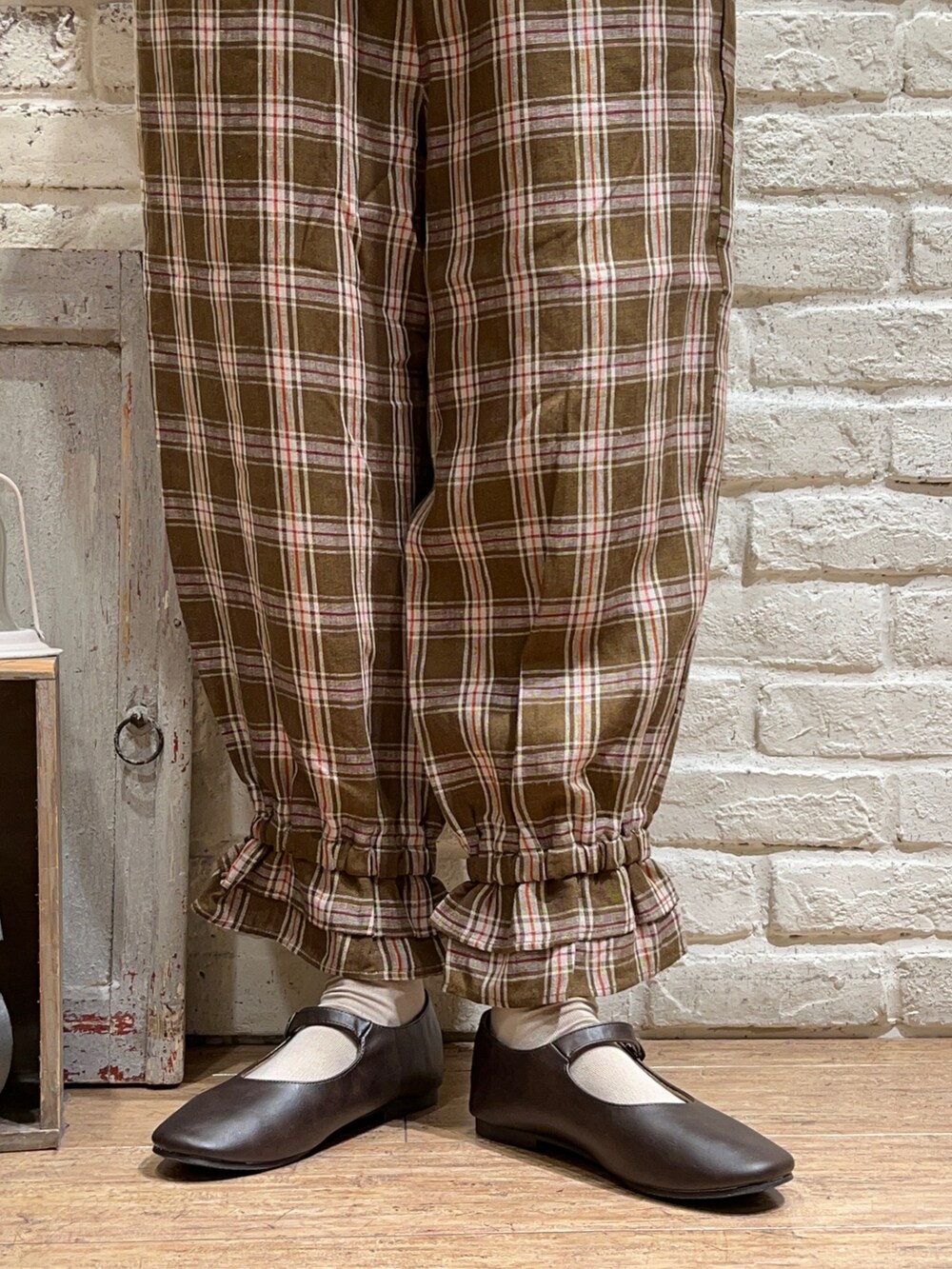 ホワイト系のシャツ/ブラウス、ブラウン系のベスト、ブラウン系のハンドバッグを着用したレディースの秋コーディネートの5枚目の写真