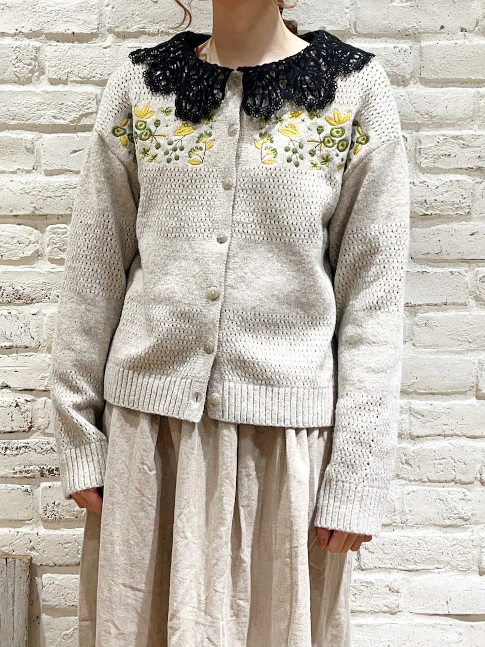 ブラック系のシャツ/ブラウス、ピンク系のカーディガン/ボレロ、ベージュ系のスカートを着用したレディースの冬コーディネートの2枚目の写真