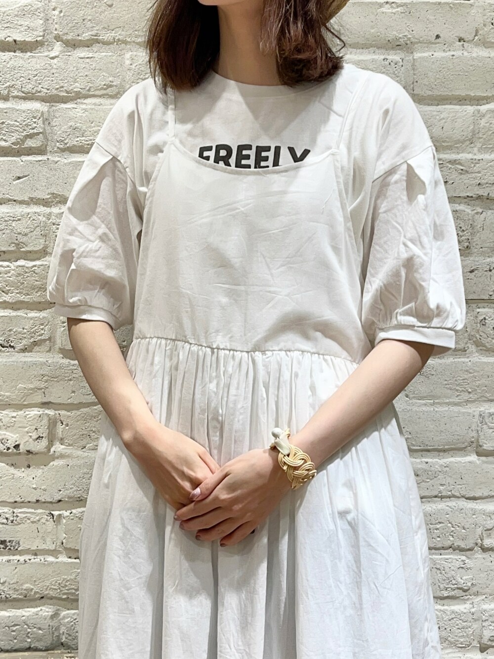 ホワイト系のTシャツ/カットソー、ホワイト系のハンドバッグ、ホワイト系のワンピースを着用したレディースの秋コーディネートの2枚目の写真
