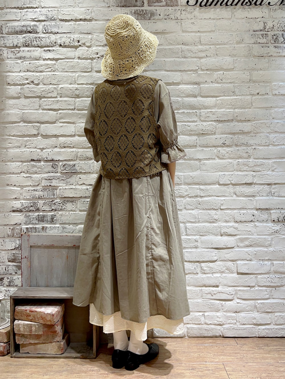 グリーン系のベスト、グリーン系のワンピース、ホワイト系のスカートを着用したレディースの秋コーディネートの3枚目の写真