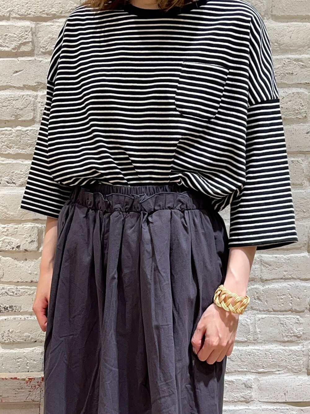 グレー系のTシャツ/カットソー、グレー系のハンドバッグ、グレー系のその他パンツを着用したレディースの秋コーディネートの2枚目の写真