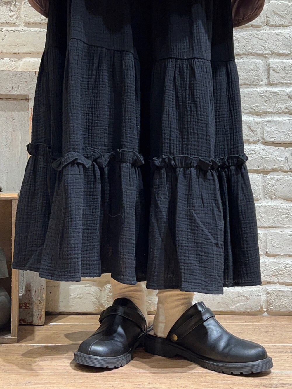 ホワイト系のシャツ/ブラウス、ホワイト系のニット/セーター、ブラック系のスカートを着用したレディースの冬コーディネートの5枚目の写真