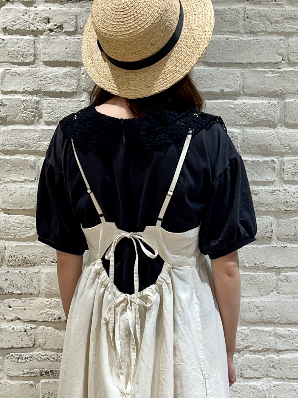 グレー系のTシャツ/カットソー、ブラック系のハンドバッグ、ホワイト系のワンピースを着用したレディースの秋コーディネートの4枚目の写真