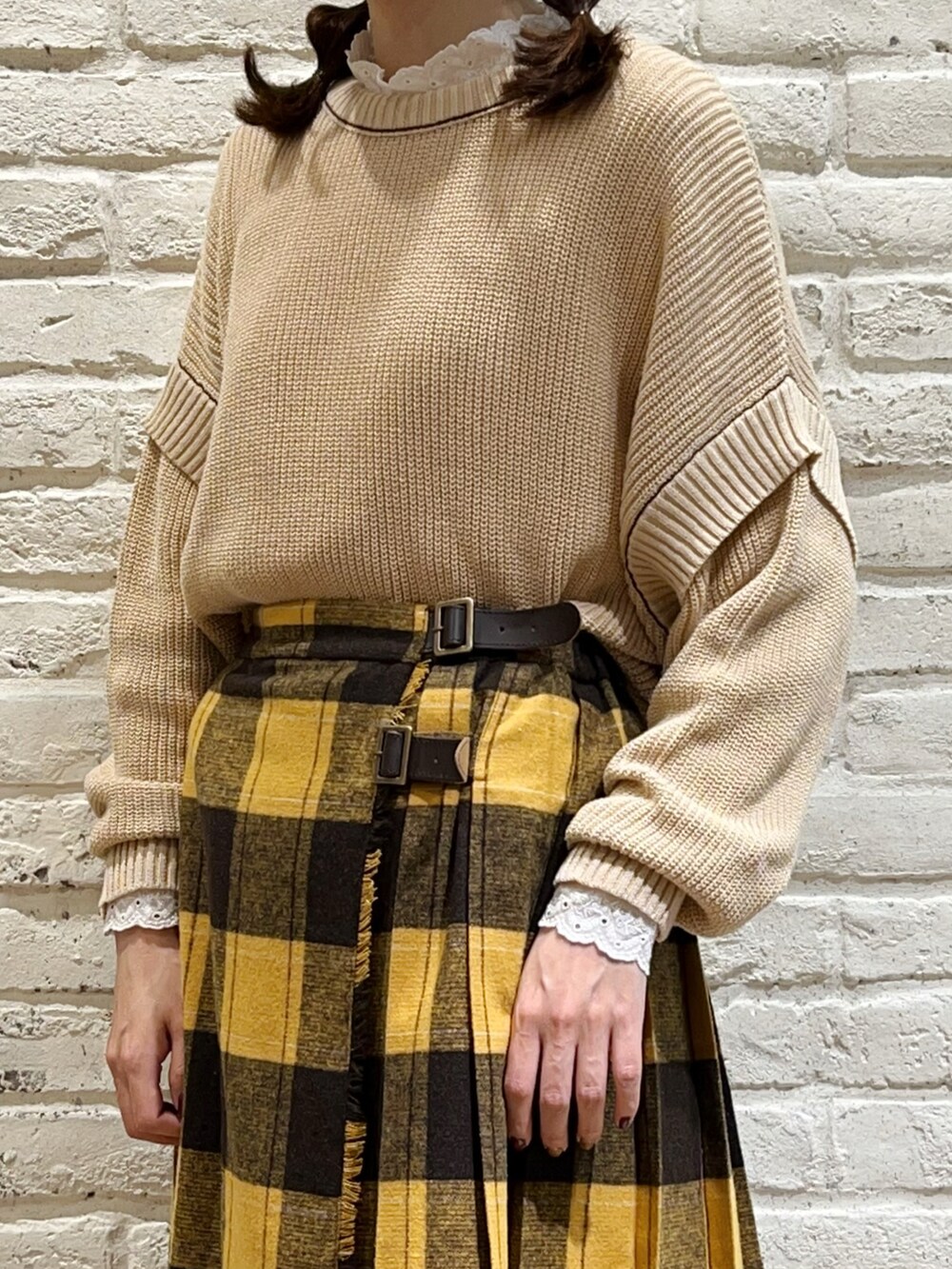 ホワイト系のTシャツ/カットソー、ブラウン系のポンチョ、ホワイト系のニット/セーターを着用したレディースの秋コーディネートの4枚目の写真